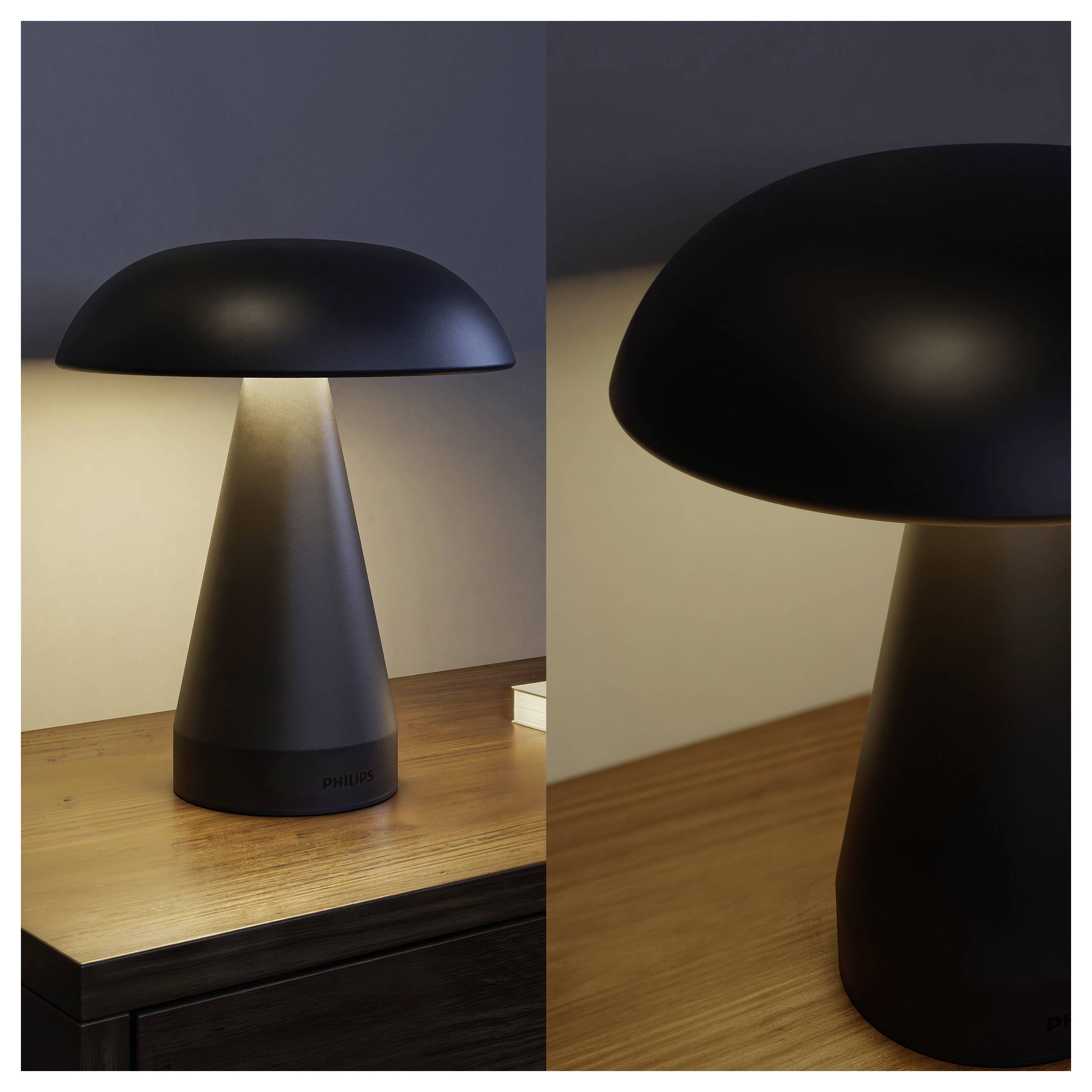 Black mushroom-shaped table lamp on a wooden desk, shown full and in close-up, with a warm glow underneath the wide shade.