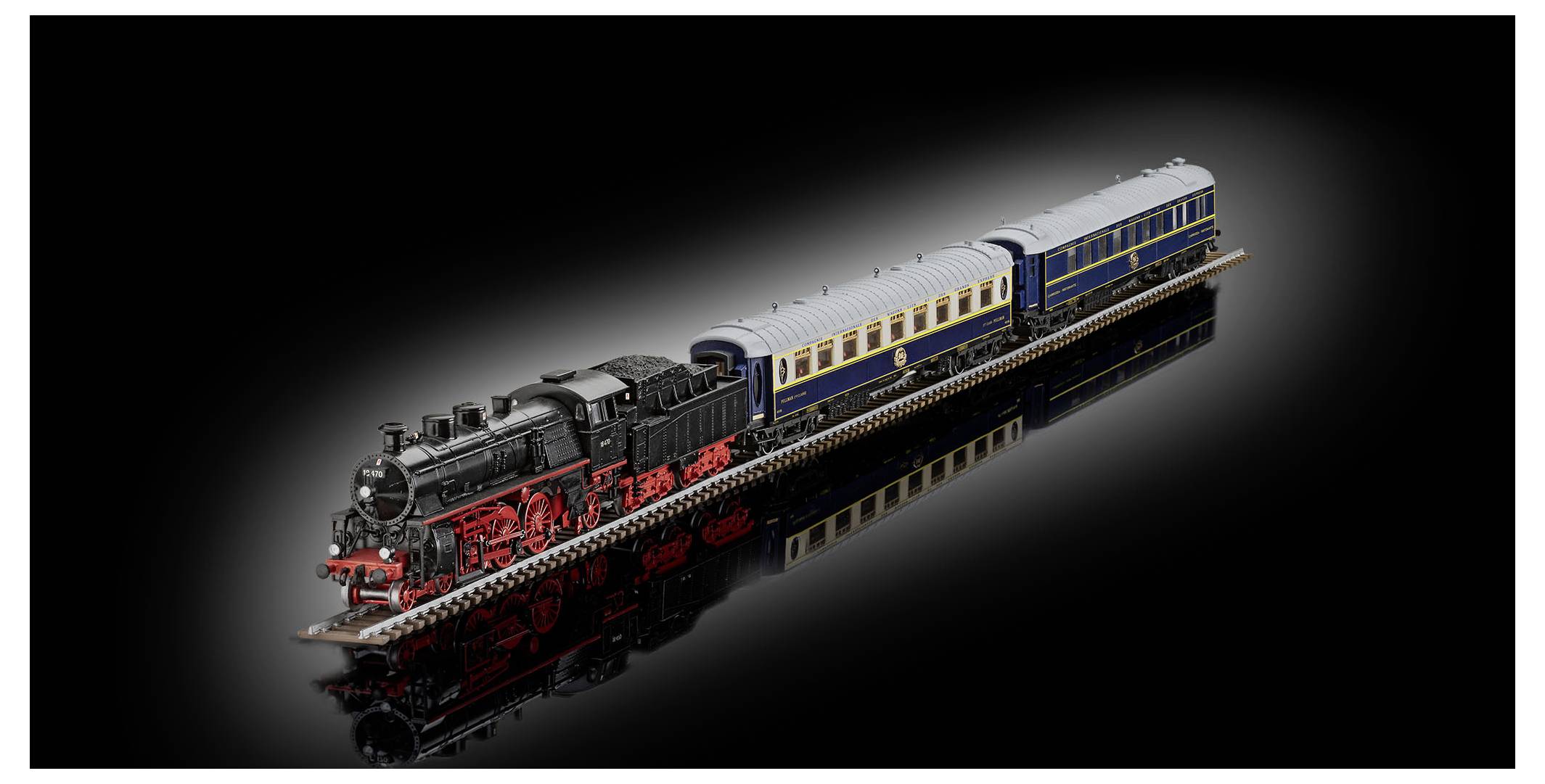 LEGO-style black steam locomotive pulling two passenger cars on a glossy black background, shown in three-quarter view with its reflection below.