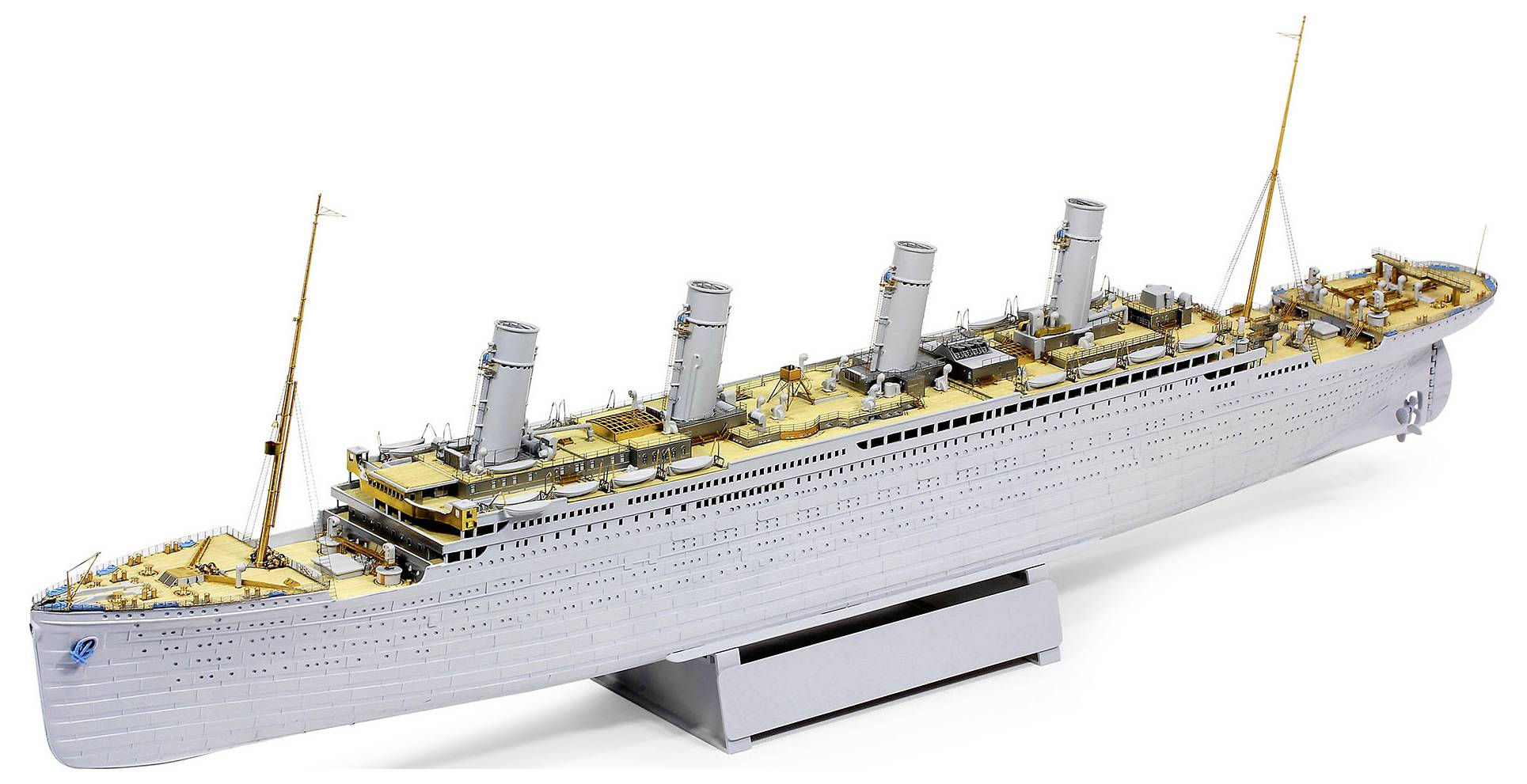 Model of a large ocean liner on a display stand, shown in side view with four smokestacks and deck details.