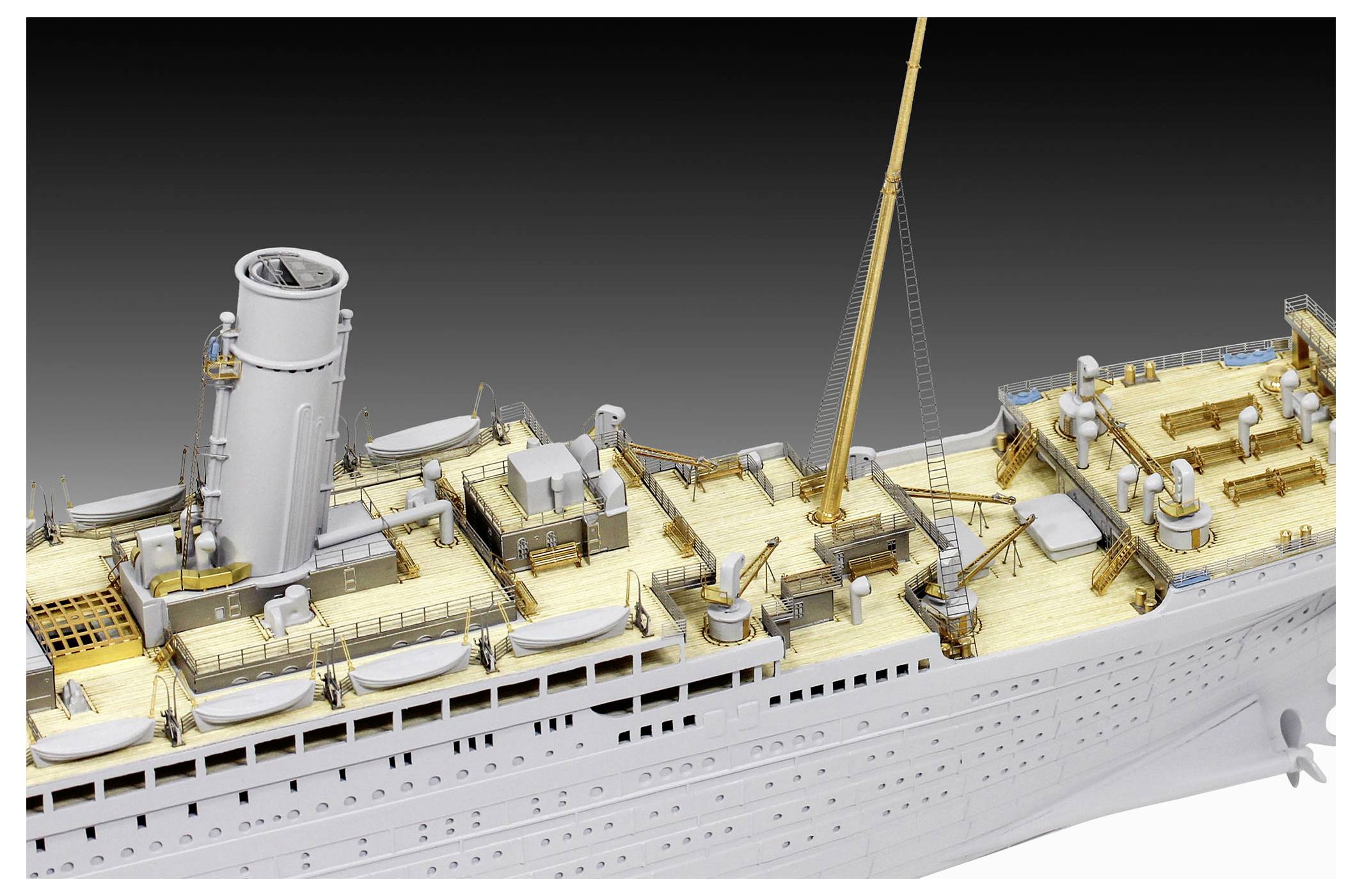Model of a large ocean liner under construction, showing deck details, lifeboats, funnels, and a crane on the ship’s upper deck.