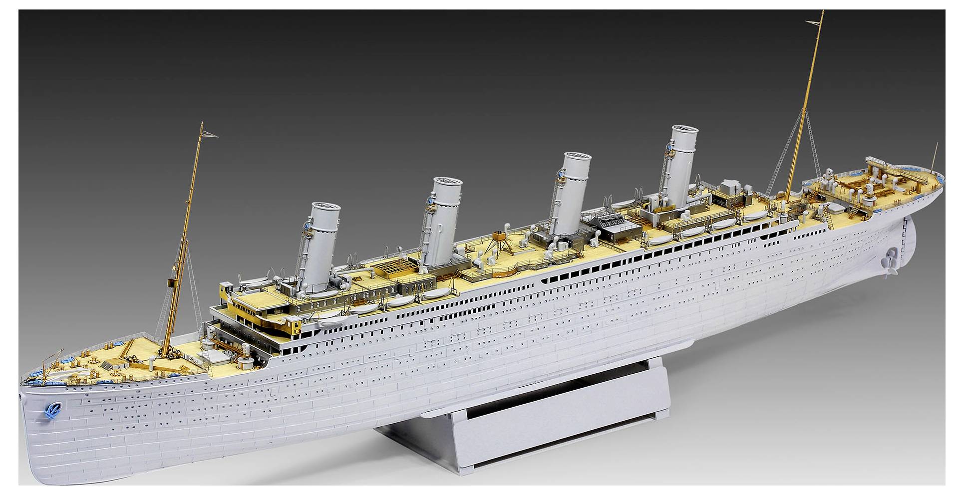 A large model ocean liner on a display stand, shown in side view with four smokestacks and a white hull.