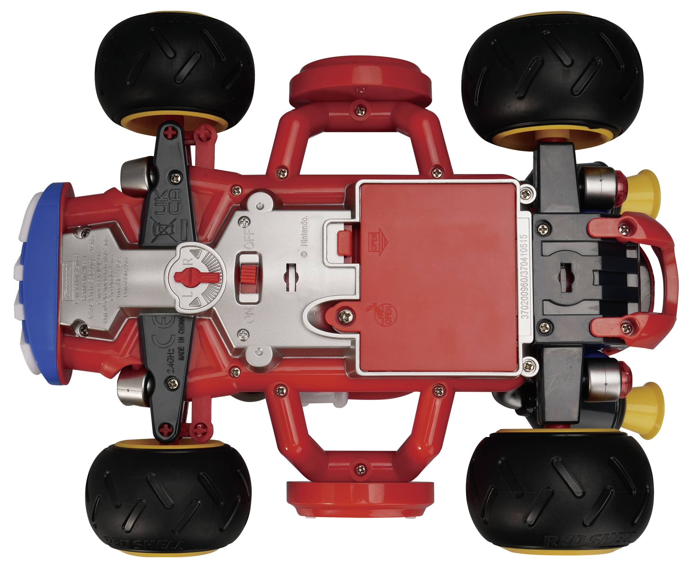 Top view of a red-and-black toy stunt car with four large wheels and a central battery compartment on a white background.