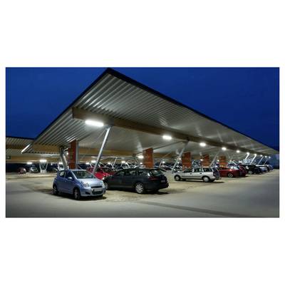 Nighttime view of a modern covered parking lot with several parked cars under a large metal canopy lit by overhead lights.