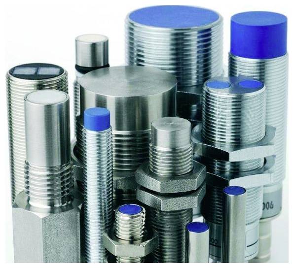 Assorted metal bolts, nuts, and threaded fasteners stacked upright in a product display.
