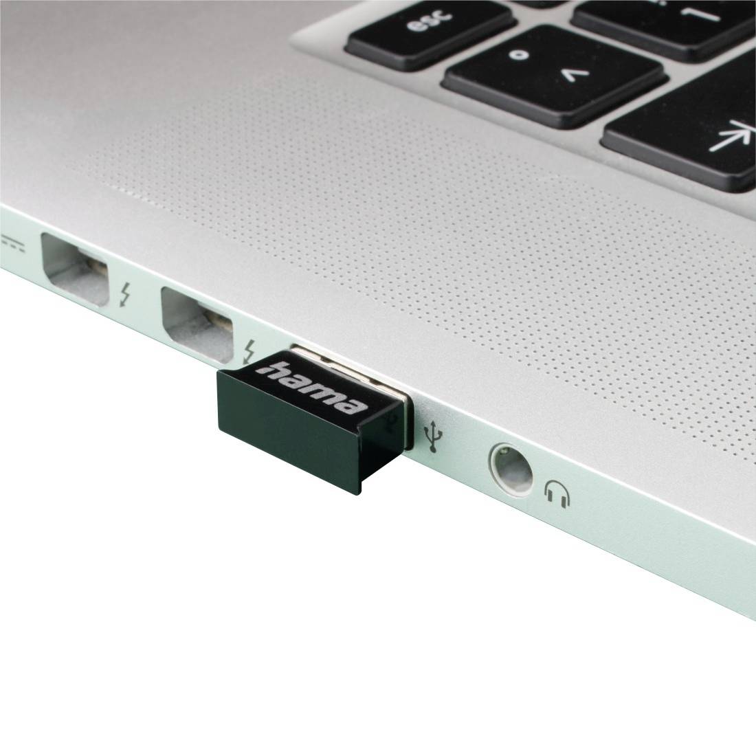 Close-up of a laptop edge with a Hama USB device plugged into a port, alongside Ethernet, power, and headphone jacks.