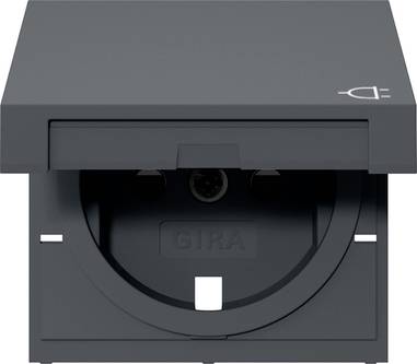 Black Gira electrical outlet with a protective flip cover, front view.<br>