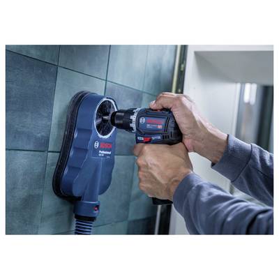 Person using a Bosch power drill attached to a tile vacuum/suction tool on a bathroom wall to drill a hole<br>