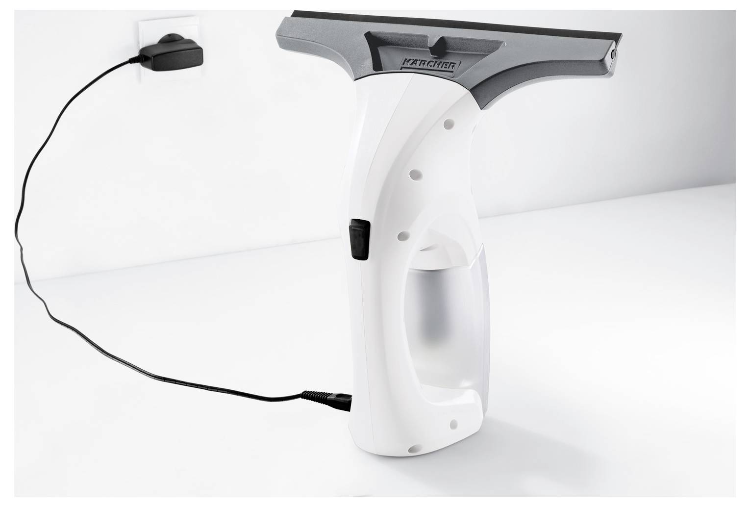 White handheld window cleaner with black power cord and charger base on a white surface, shown in profile.