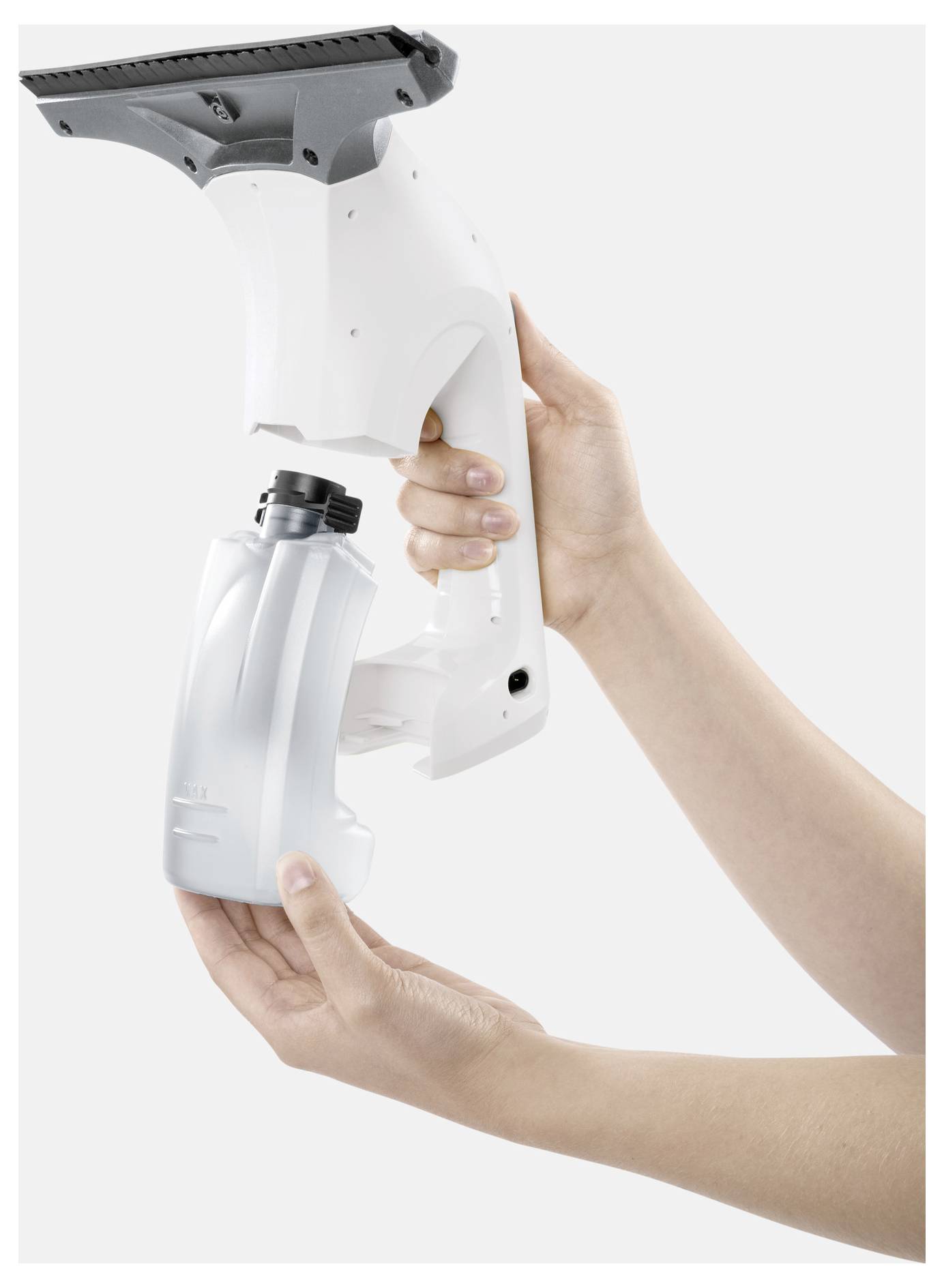 Hands holding a cordless handheld steam cleaner with a rectangular nozzle and detachable water tank against a white background.