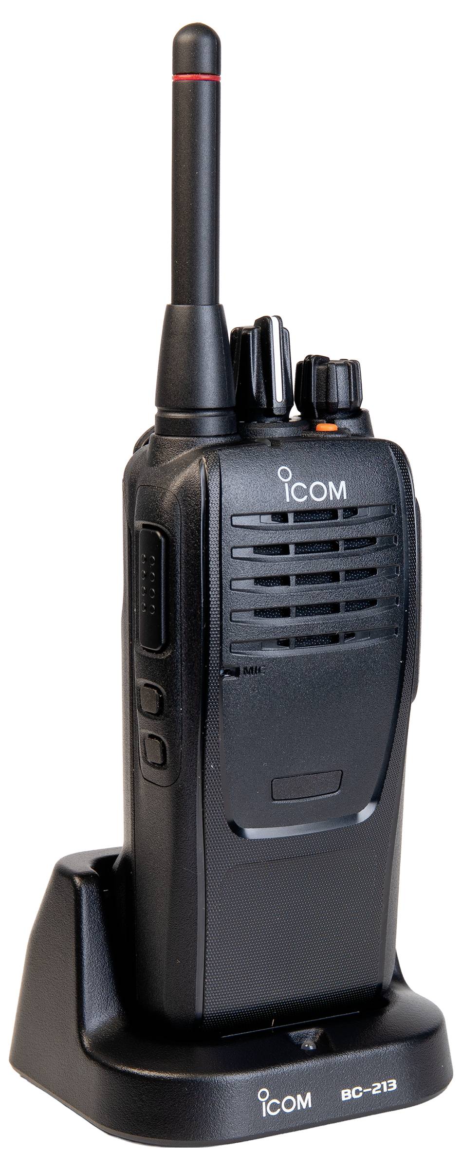 Black Icom handheld two-way radio on a charging base with antenna and push buttons.