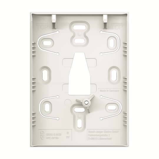 White plastic wall-mount backplate with multiple screw slots, central cable opening, and latch features for hanging or securing a device.