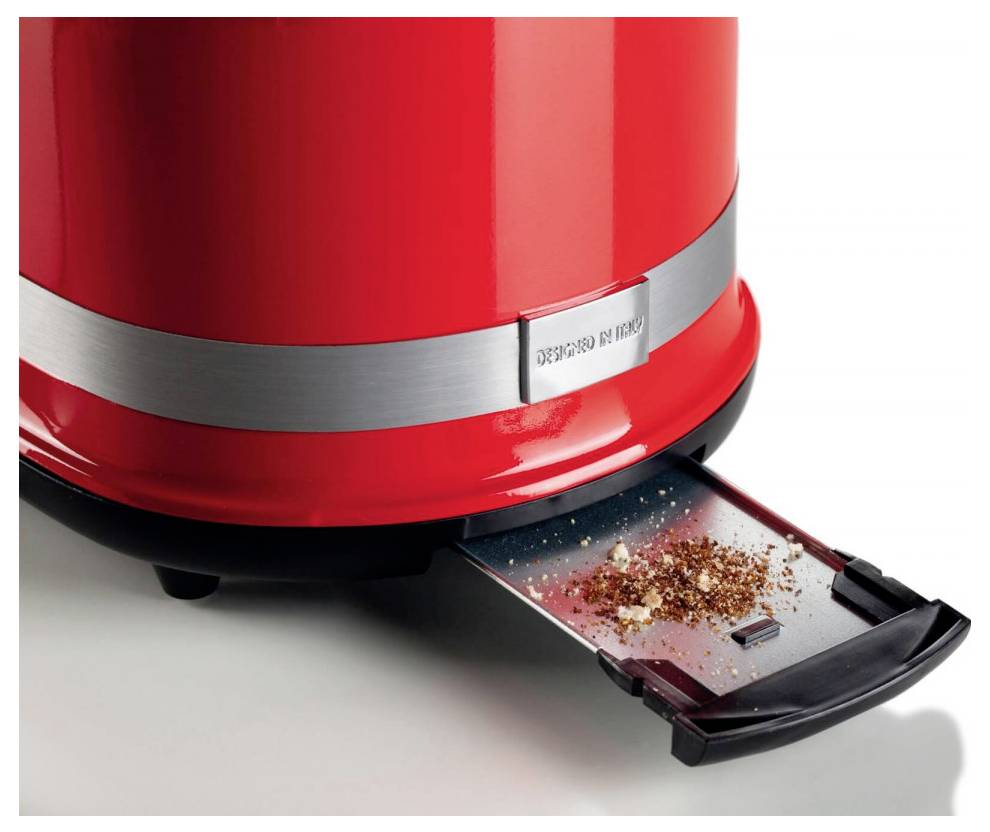 Red electric kettle with a removable drip tray collecting spilled grounds on a white surface.
