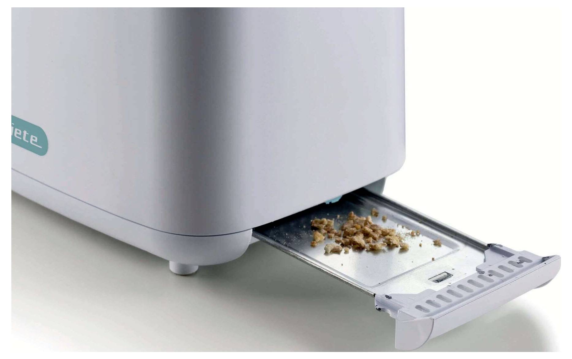Open smart oven with a pull-out crumb tray holding crumbs, shown in a clean white kitchen setting