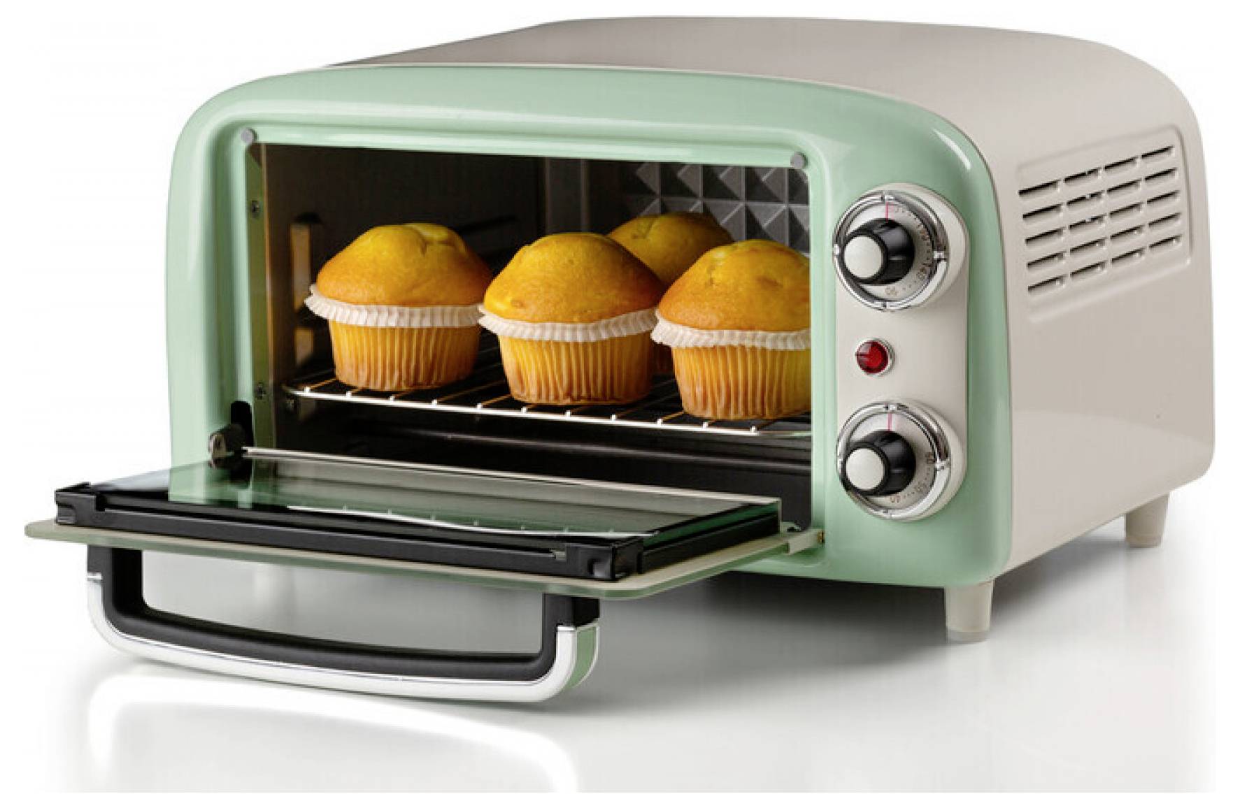Mini countertop toaster oven with glass door open, baking four muffins inside on a rack.<br>