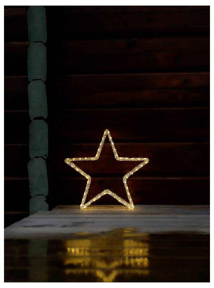 Illuminated five-point star decoration glowing on a porch, reflected on a wet wooden surface.<br>