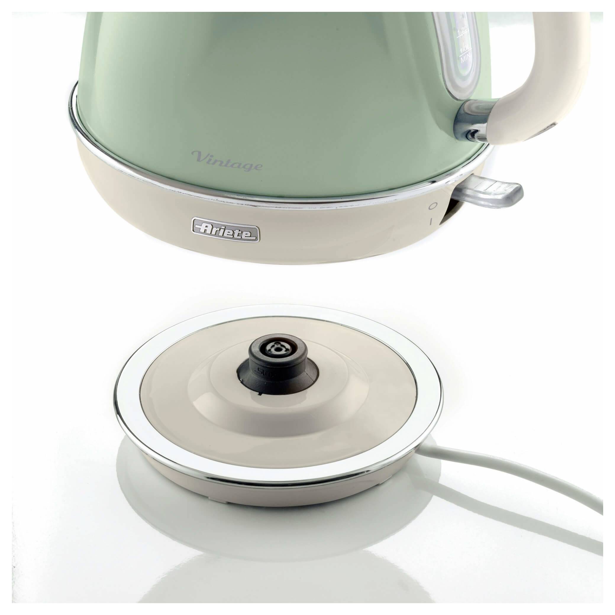 Mint green and cream electric kettle shown above its round power base with cord attached.<br>