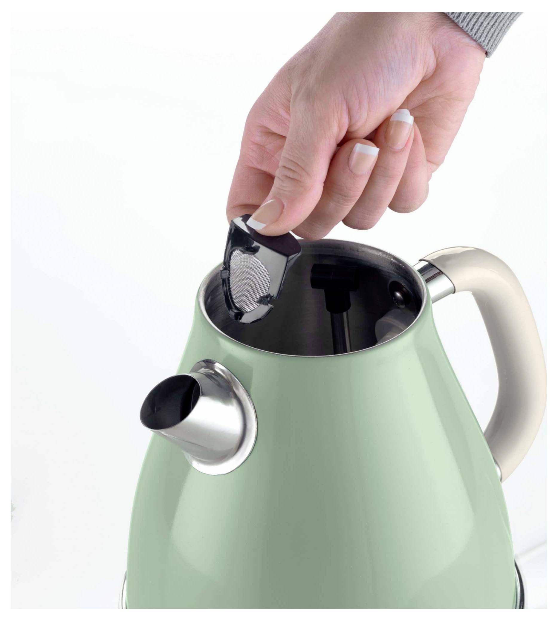 Hand placing tea bag into a mint green electric kettle<br>