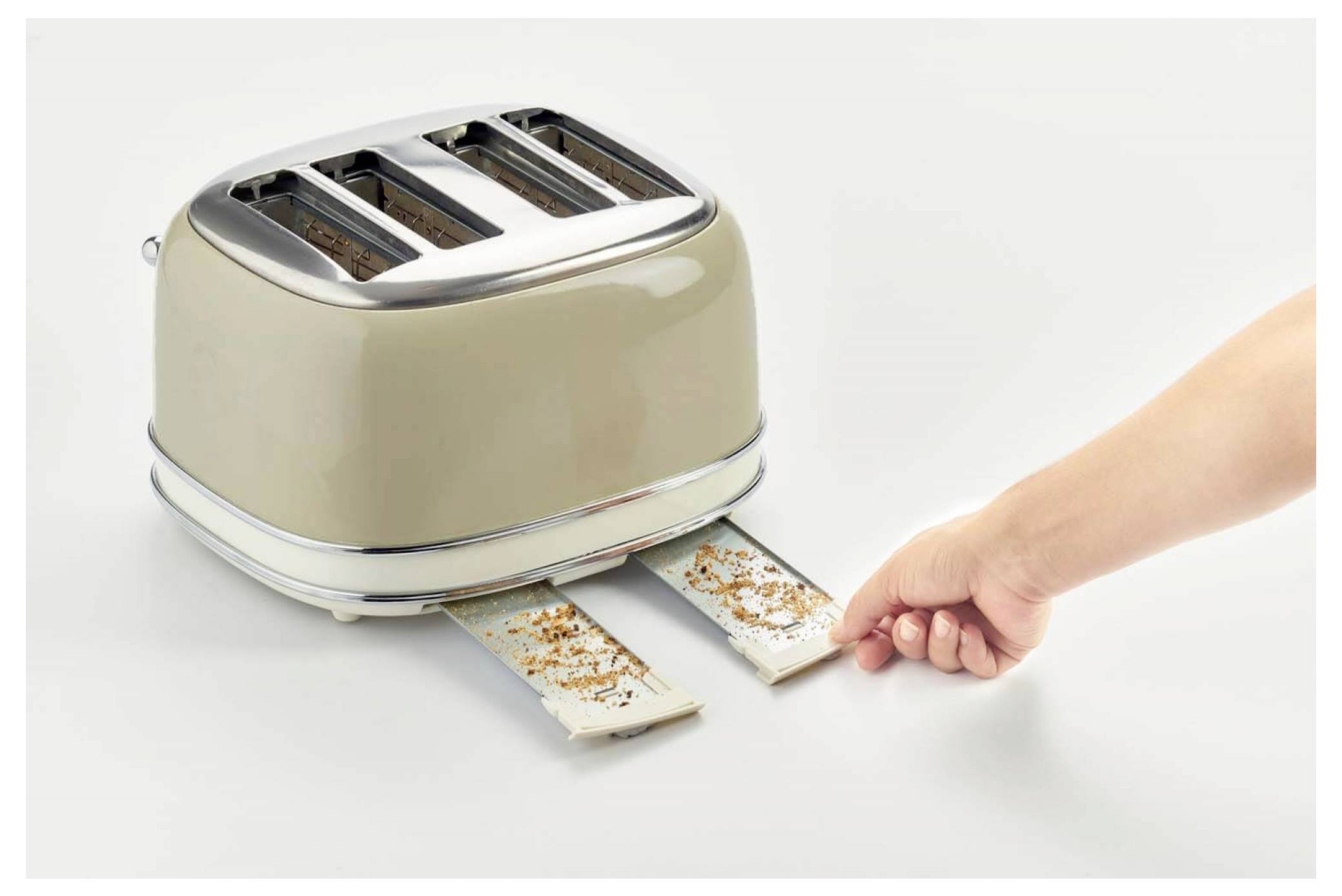 A hand pulls out two toasted slices from a beige four-slot toaster on a white surface, with crumbs on the trays.
