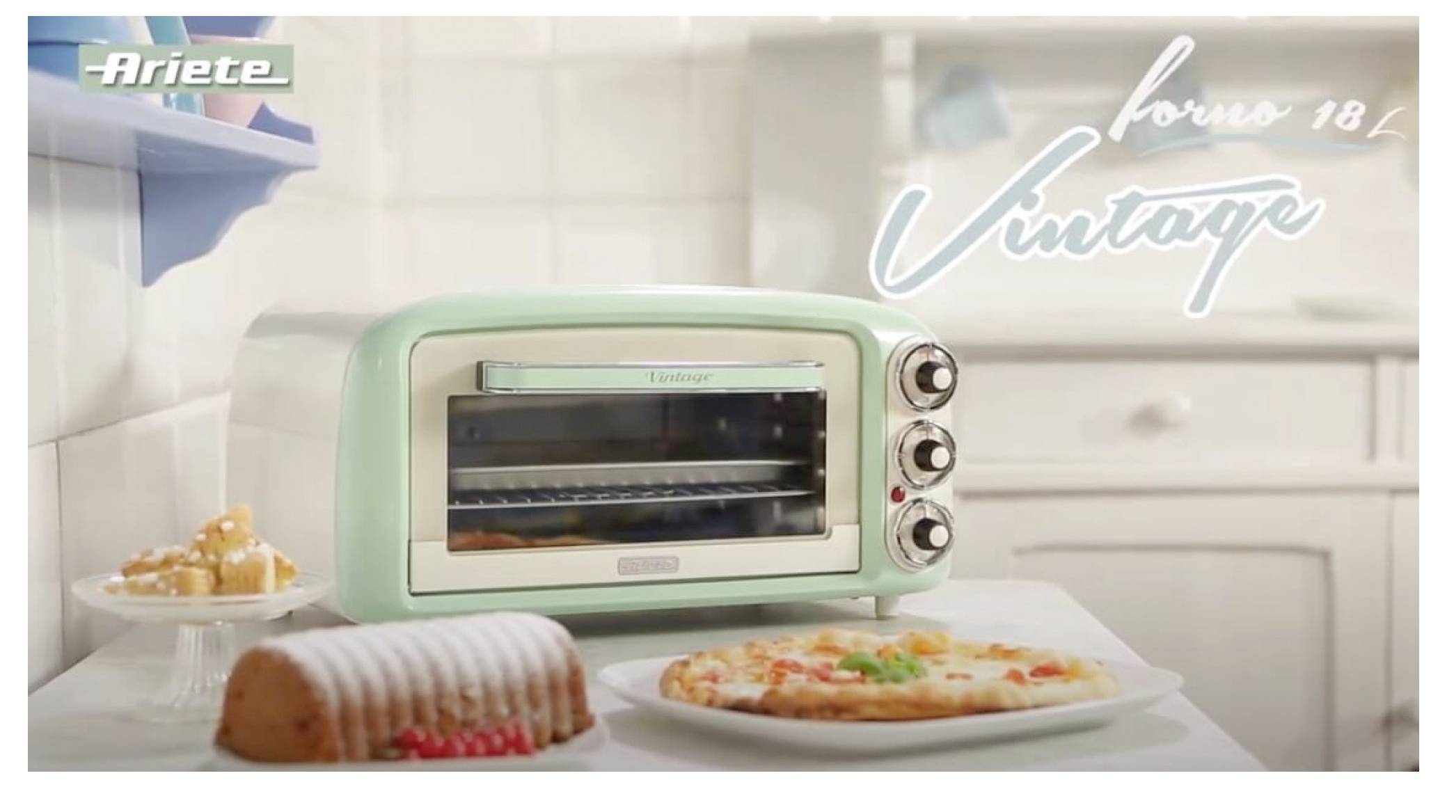 A mint-green Ariete 'forno 18 Vintage' countertop oven sits on a kitchen counter, with a cake, pie, and pizza nearby.<br>