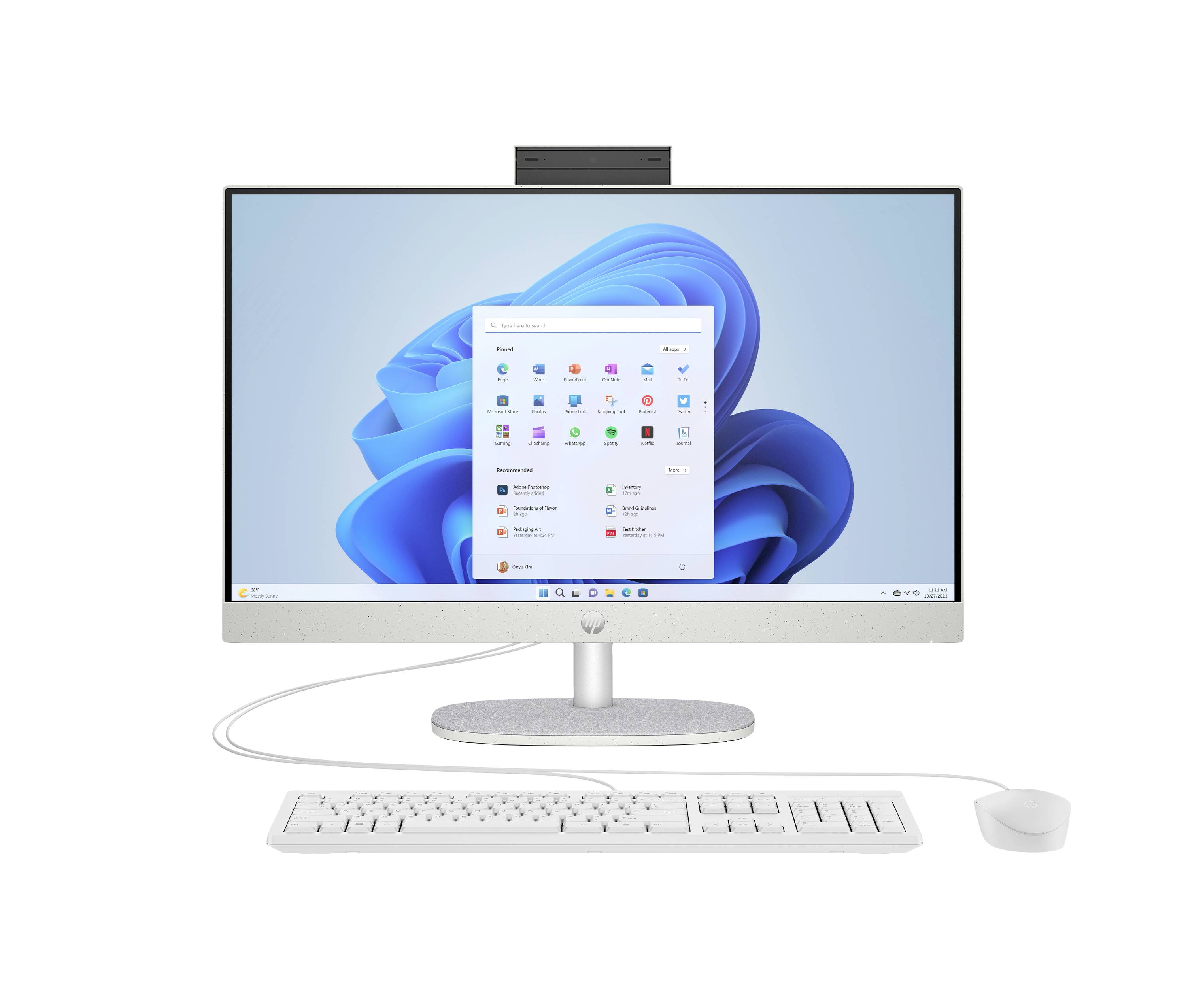 A silver all-in-one desktop computer with Windows 11 on screen, shown with a keyboard, mouse, and webcam on a white background.