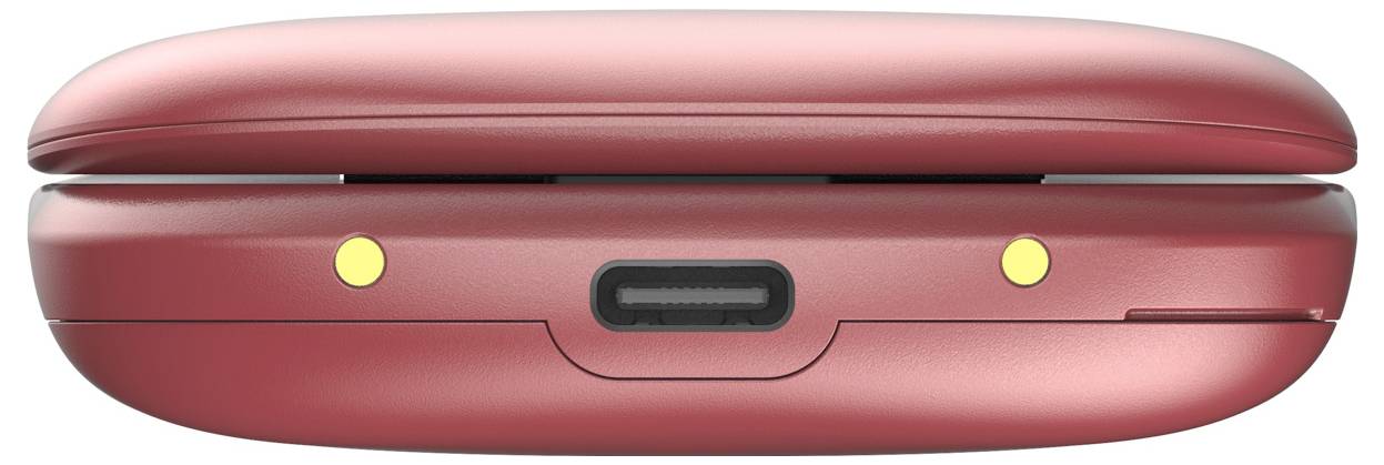 Close-up of a closed red clamshell device, showing the front edge with two yellow indicator lights and a centered charging port.