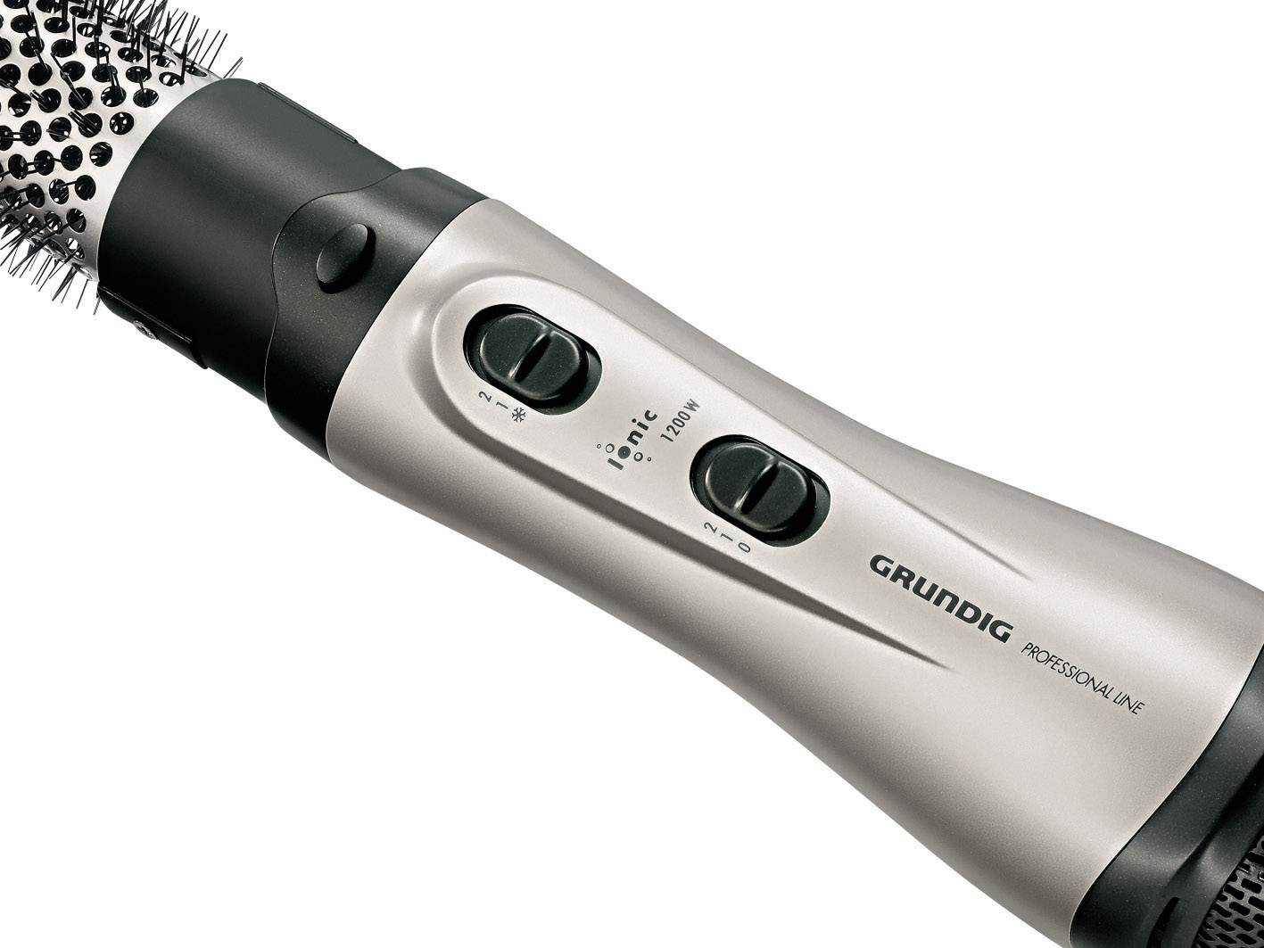 Hot air brush with silver handle and black bristles. Two switches for temperature control, 'Grundig' brand visible.