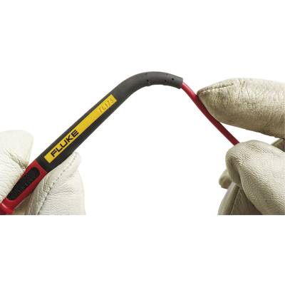 A person wearing gloves is holding a flexible cable with an insulated handle that reads 'FLUKE TL175'.