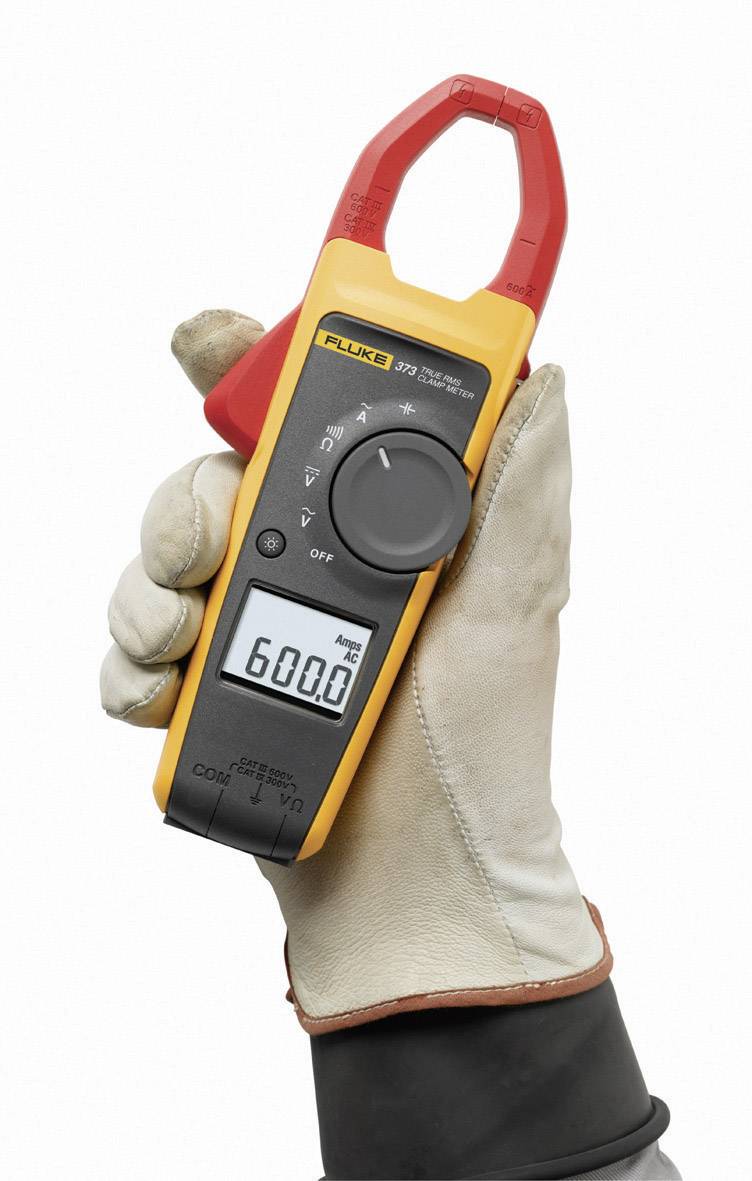 A hand is holding a current clamp multimeter, displaying 600.0 A alternating current. The device is yellow and black and bears the inscription 'Fluke'.