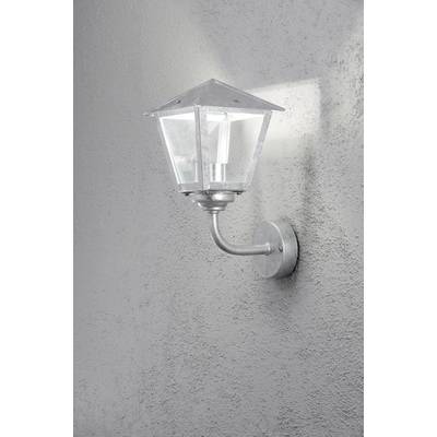 A silver wall light in the shape of a lantern is mounted on a grey, textured wall. It is casting a soft light.