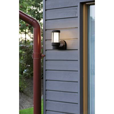 Exterior wall light on a grey wooden facade beside a red downpipe, illuminated in daylight, accentuating modern architectural features.