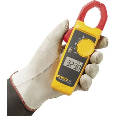 A hand is holding a yellow ammeter with a red clamp. The display shows 32.30 amperes.