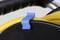 Blue clamp secures yellow cable on black cable reel; handle visible, shows use for cable organisation.