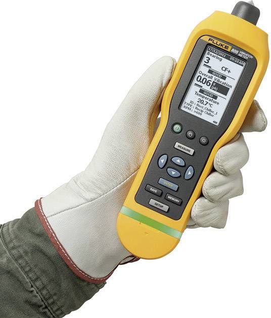 A hand in a glove holds a yellow measuring device that is monitoring particles in the air. It displays a reading of 0.06 Pm.