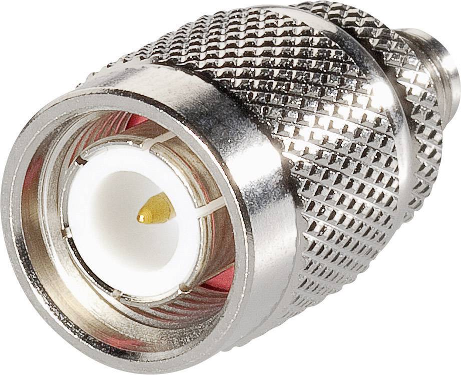 A metallic coaxial plug with a knurled casing and a central pin for connecting cables in technical equipment.