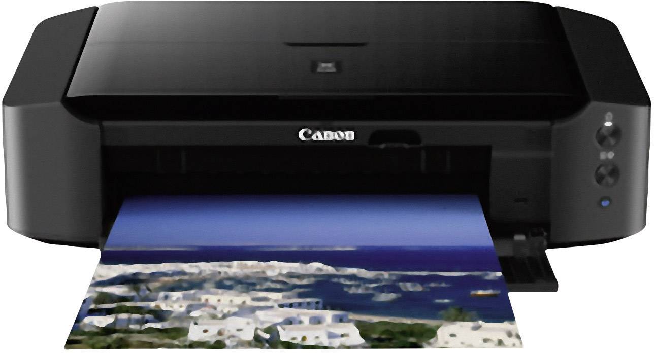 A black printer is printing a photograph of a coastal landscape with white buildings and blue sea.