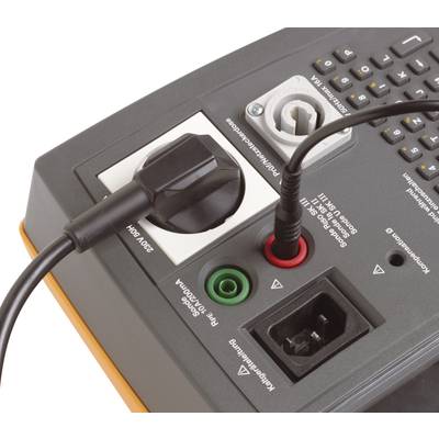 A measuring device in close-up view, featuring multiple ports, including power connection and sockets for various measurement cable types.
