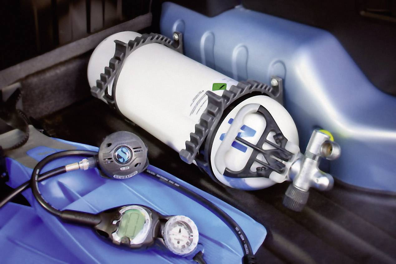 A diving apparatus with an oxygen tank and pressure gauge on a blue mat, ready for a dive.