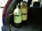 Two diving cylinders secured in a car. One cylinder is green and the other yellow.