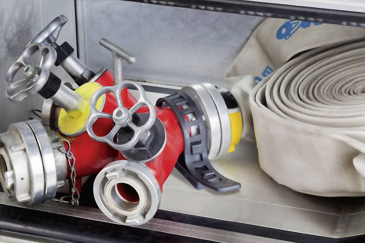 Fire hoses and valves in a cabinet. Primary tools for firefighting and water regulation, neatly stored.