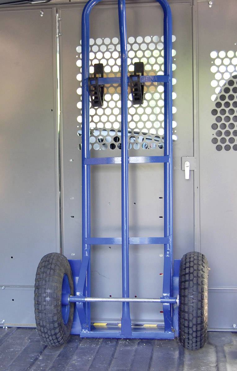 'Two-wheeled blue handcart leaning against a wall; handle and wheels clearly visible. Used for transporting heavy items.'
