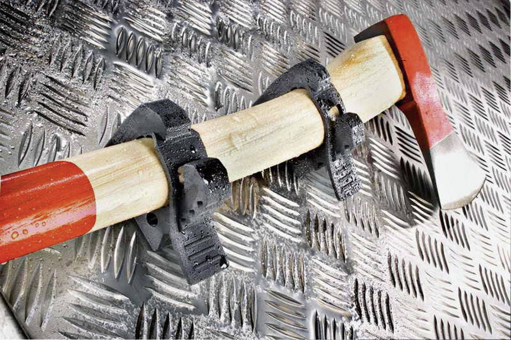 An axe mounted in a holder on a metallic, non-slip surface.