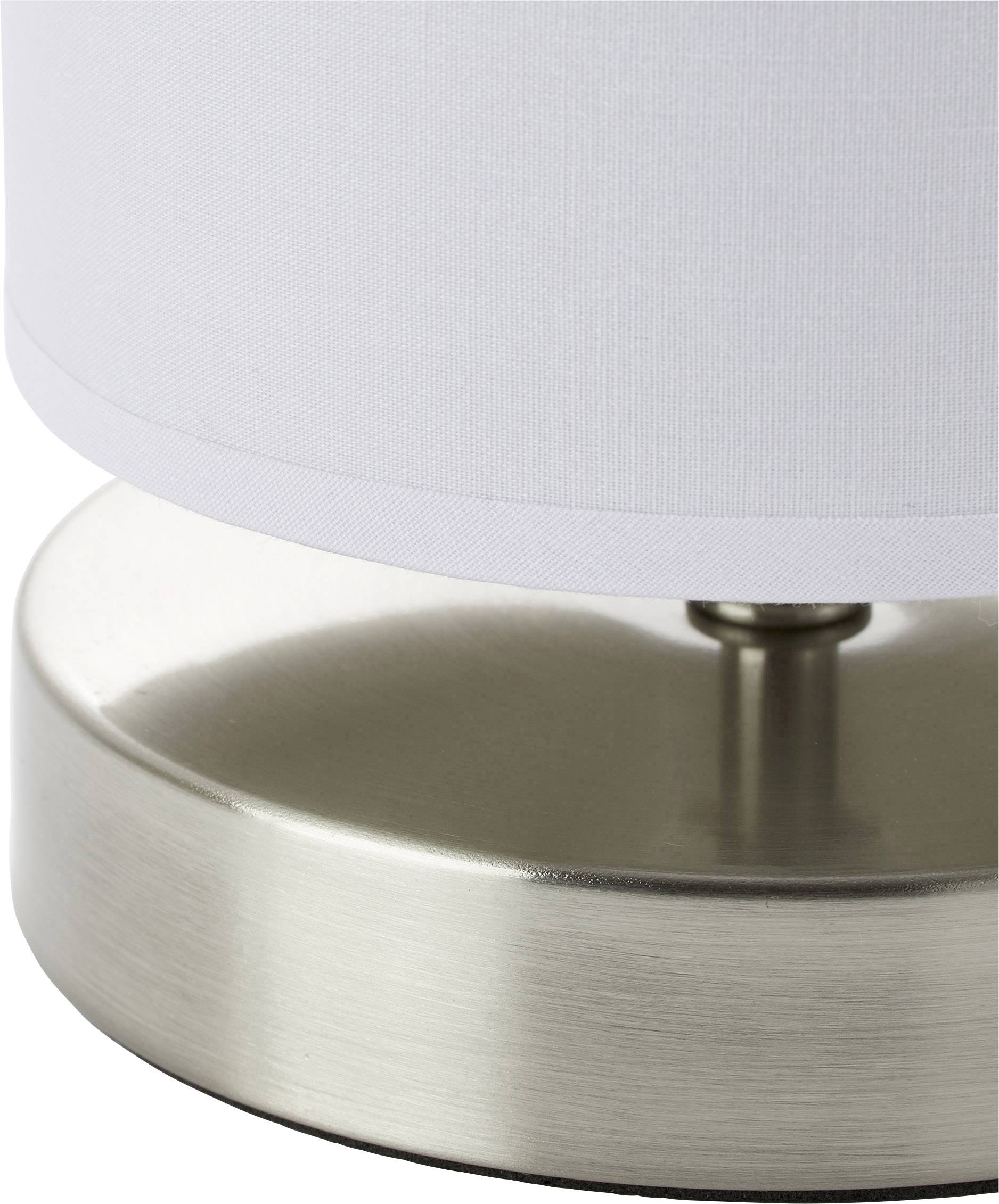Close-up of a table lamp with a white fabric shade and metallic base.