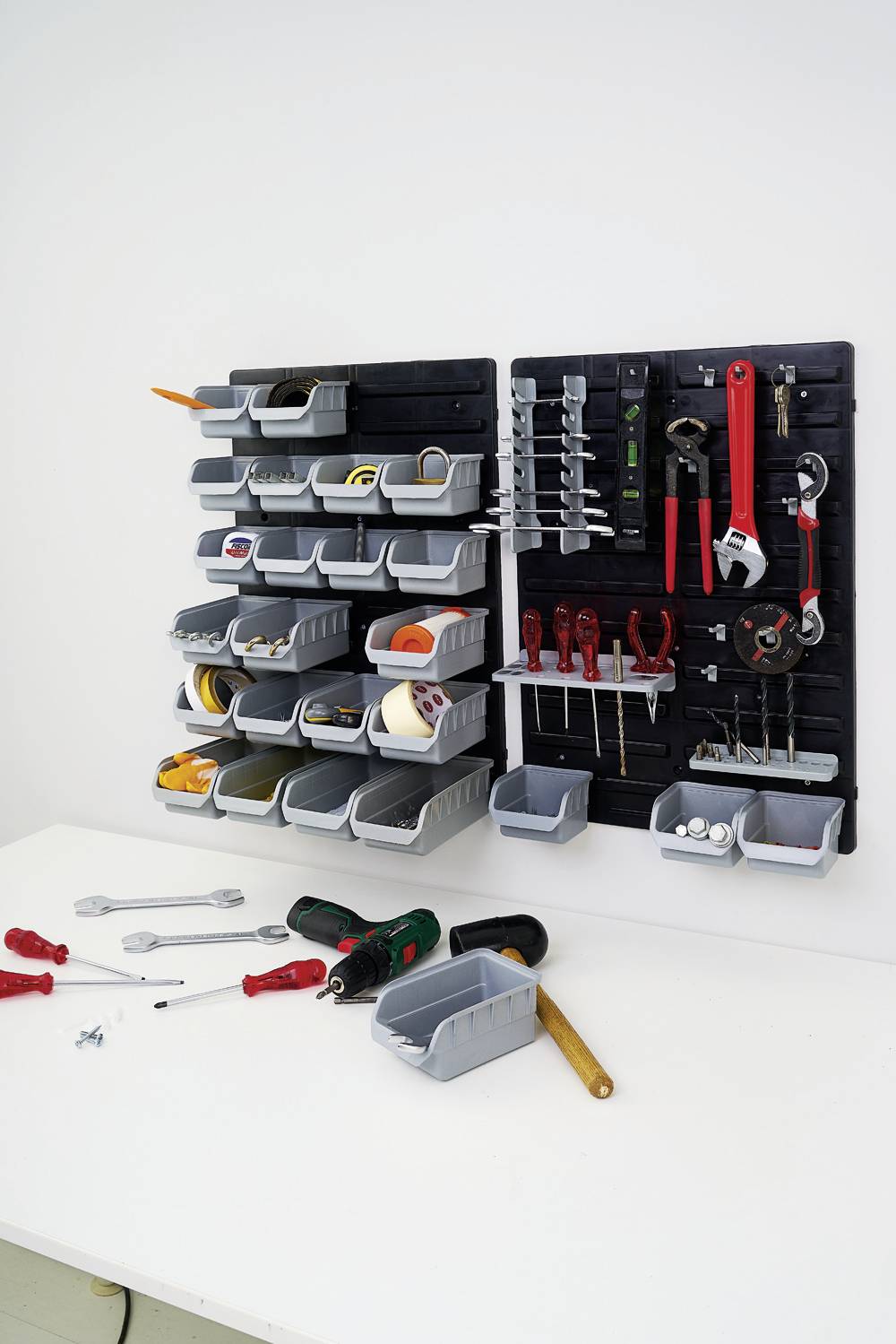 Tool wall with screwdrivers, pliers, spanners, and small parts. Below it, a workbench with drill and screws.