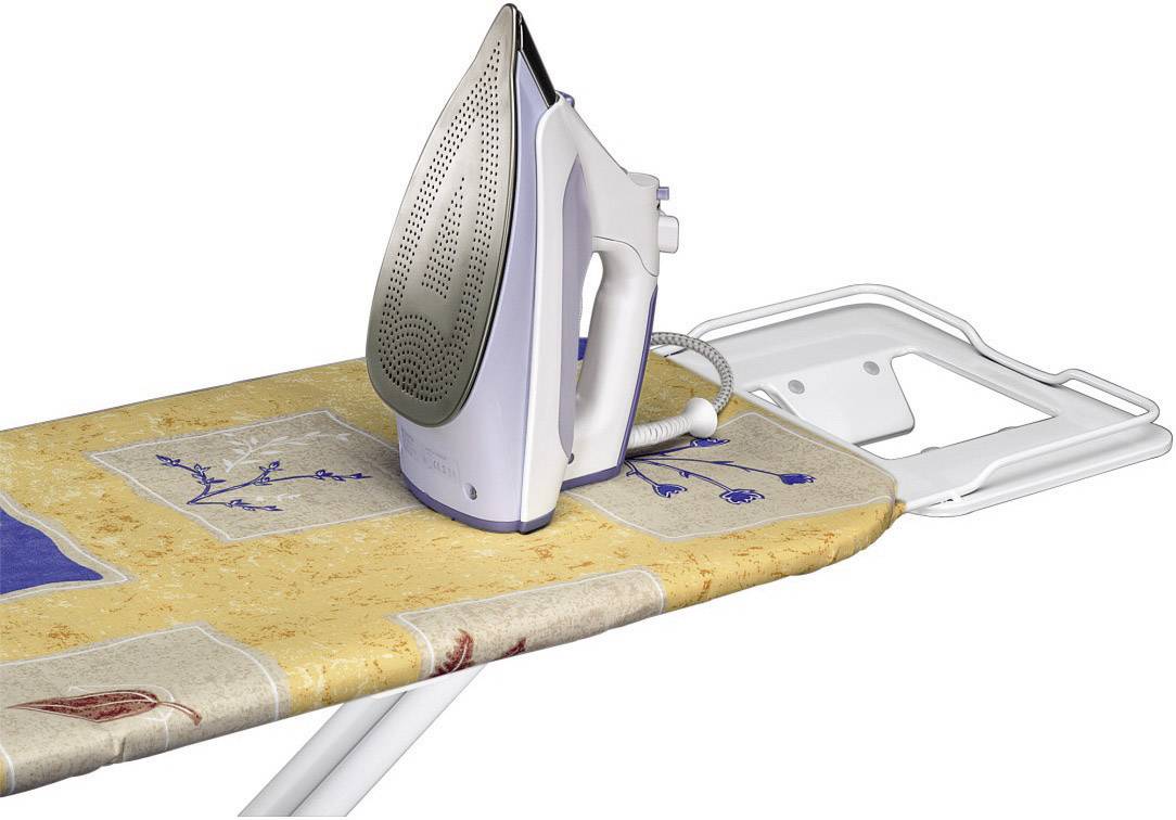 An iron placed on a floral ironing board, ready for use.
