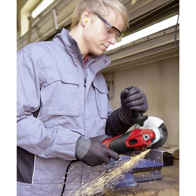A man wearing safety goggles and gloves is grinding metal with an angle grinder in a workshop. Sparks are flying from the workpiece.