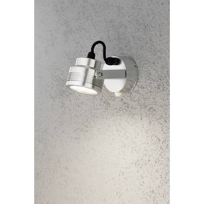 Metal wall light with a round housing, mounted on a patterned wall, illuminating downwards.