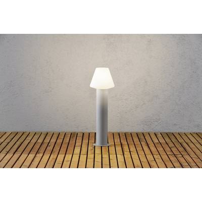 A modern floor lamp with a conical lampshade stands on a wooden floor in front of a grey wall.
