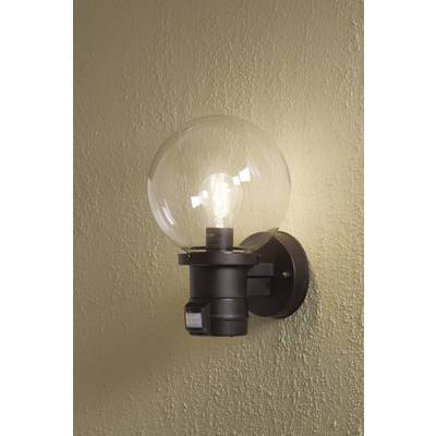 Wall light with a round, clear glass shade revealing a lit bulb. Mounted on a beige-painted wall.