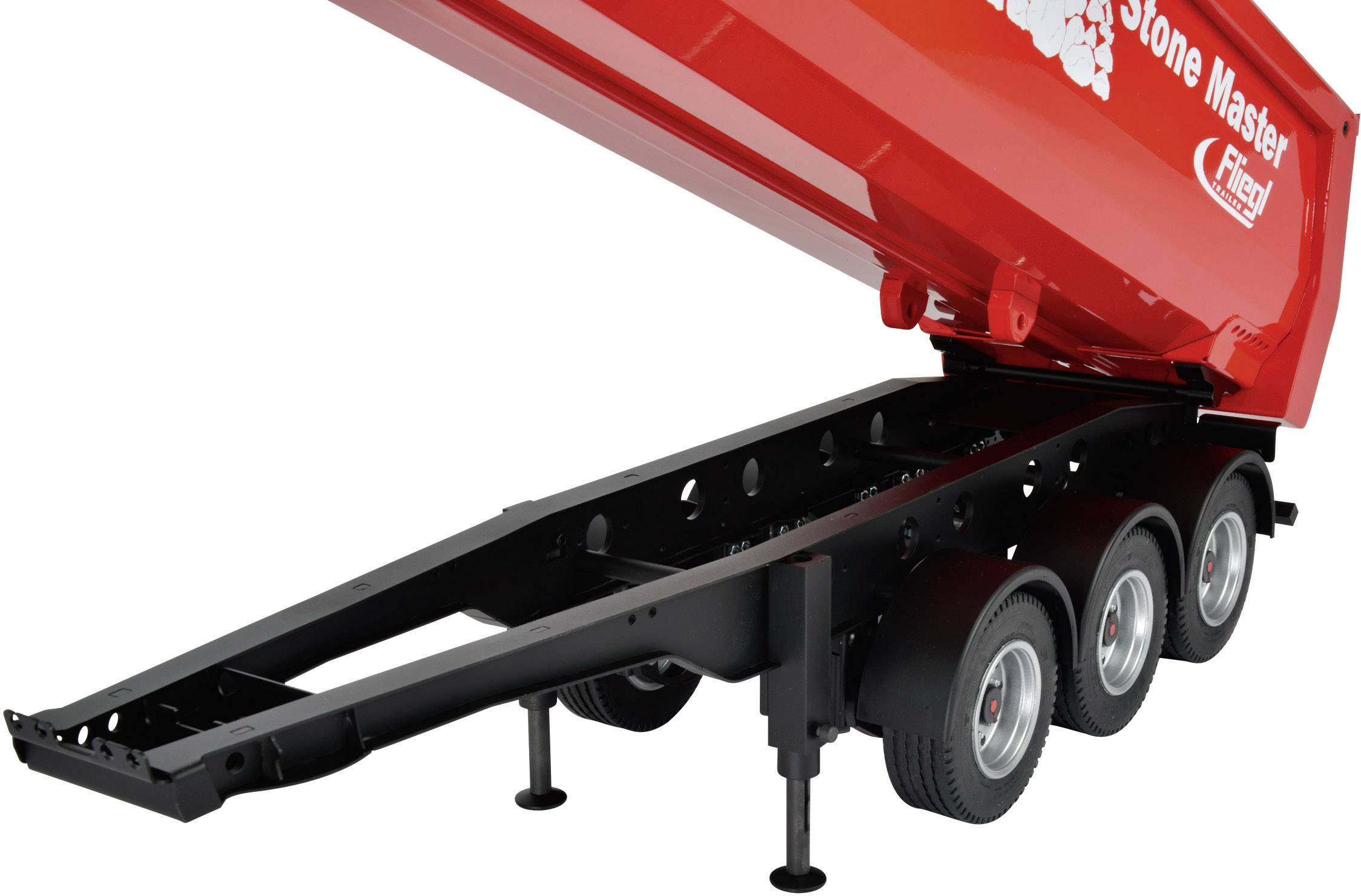 A red tipping trailer with three axles and black tyres is partially raised, revealing the lower frame.