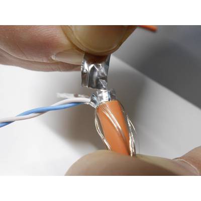 A person is demonstrating the stripping of an orange cable, revealing the silver protective foil underneath.